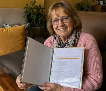 Brigitte M. sur son canapé avec son dossier ouvert