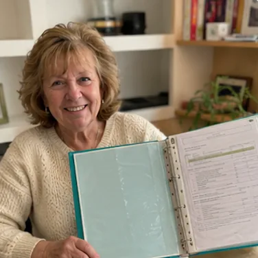 Anne-Marie T. dans son salon avec son dossier ouvert